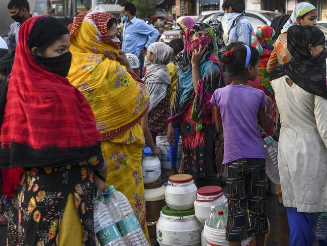 Residents queue to fill bottles and cans from a water distribution tanker as the government eases a nationwide lockdown against COVID-19 in New Delhi. Picture: AFP