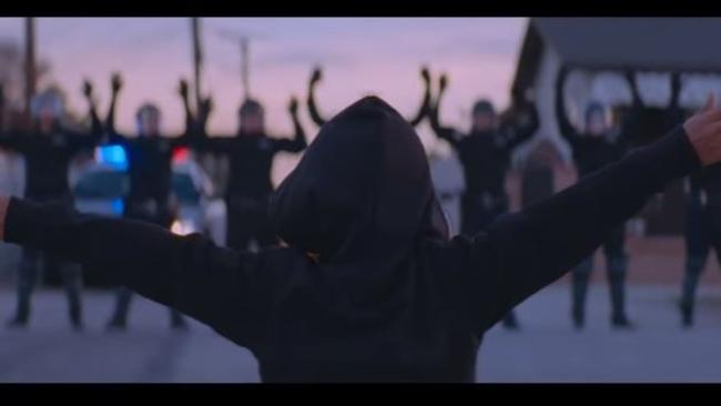 A little boy dances while a line up of riot police watch on. Picture: YouTube.