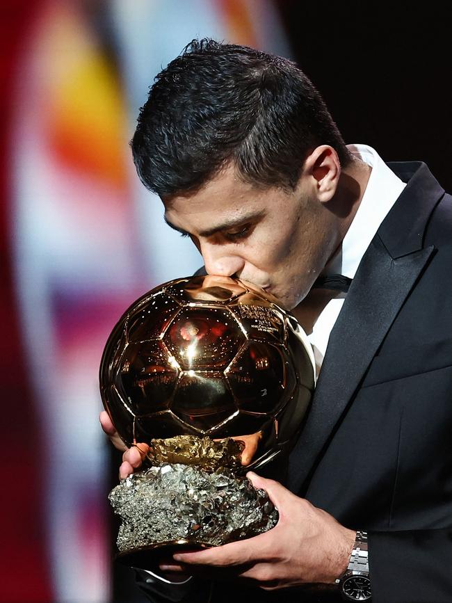 Manchester City's Spanish midfielder Rodri kisses the trophy as he receives the Ballon d'Or. (Photo by FRANCK FIFE / AFP)