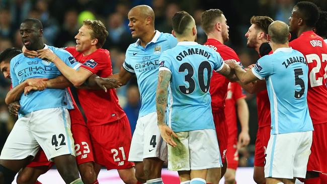 Yaya Toure of Manchester City and Adam Lallana of Liverpool clash.