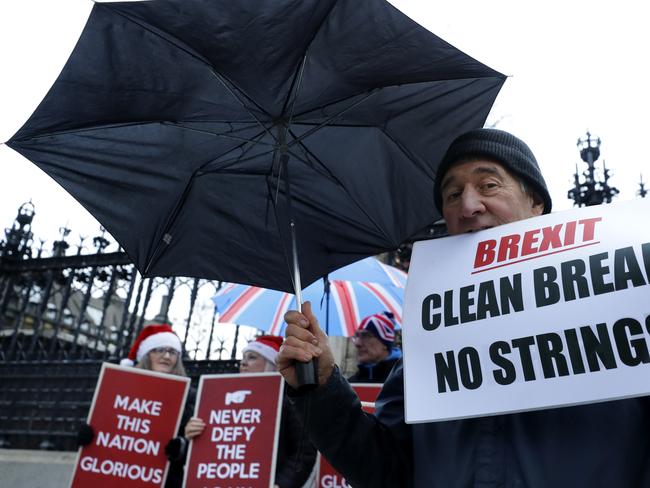 Pro Brexit demonstrators hold banners outside parliament in London. Picture: AP Photo/Kirsty Wigglesworth