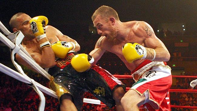 Anthony Mundine is forced on to the ropes by Garth Wood, who sprung a huge upset in their 2010 fight. 