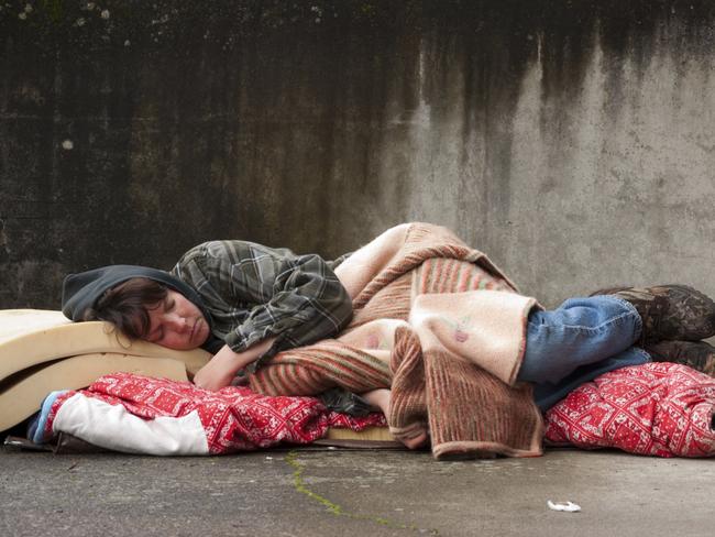 Homeless woman lying on the street.