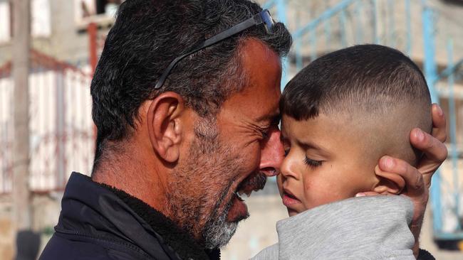 A Palestinian man holds his child as he mourns the death of his twin babies in Rafah. Picture: AFP.