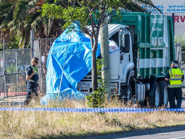 Fatal crash involving two trucks in Epping. A tarp covers the cabin of the truck from which the driver was thrown. Picture: Jake Nowakowski