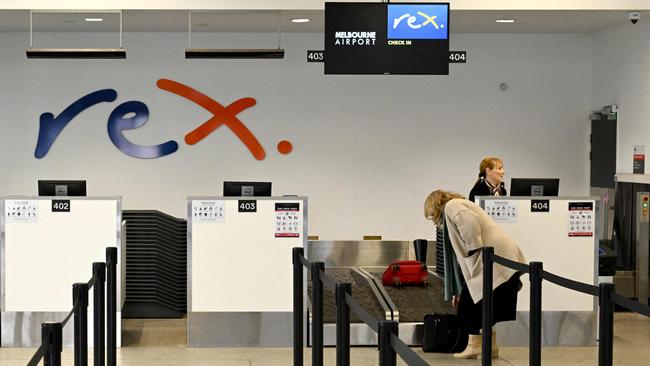 A passenger checks in for a Rex Airlines flight in July. Picture: William WEST / AFP