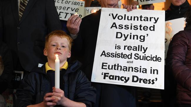 A child is seen with a candle at a pro life demonstration outside the Victorian state parliament. Picture: James Ross/AAP