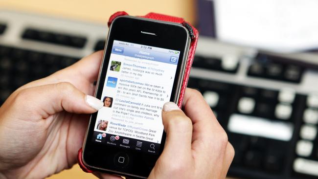 Generic photo of woman twittering on Apple iPhone in the office. Twitter has about 1.3 million users in Australia and NSW produces the largest number of tweets.