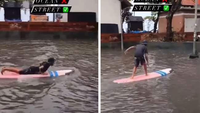 Bali tourists surfing the street after flash flooding