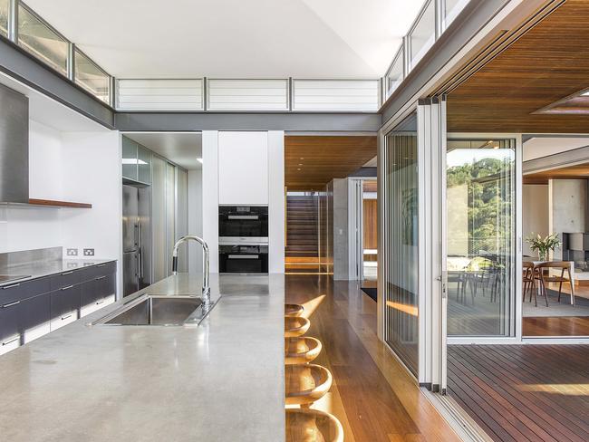 The modern kitchen opens out to a wonderous dining area.