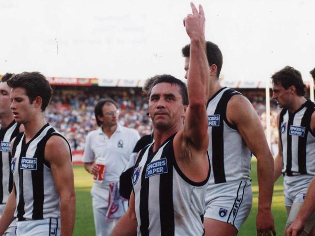 Tony Shaw gives the two-finger salute as he leaves the ground with Collingwood teammates.