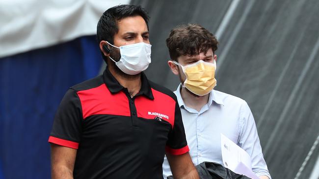 People wearing masks near the Coronavirus tent at the RBWH. Photographer: Liam Kidston.