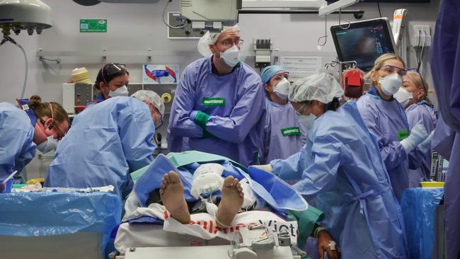 There is a careful choreography to the chaos unfolding as staff don blue gowns and masks and get to work to help the patient. Picture: David Caird