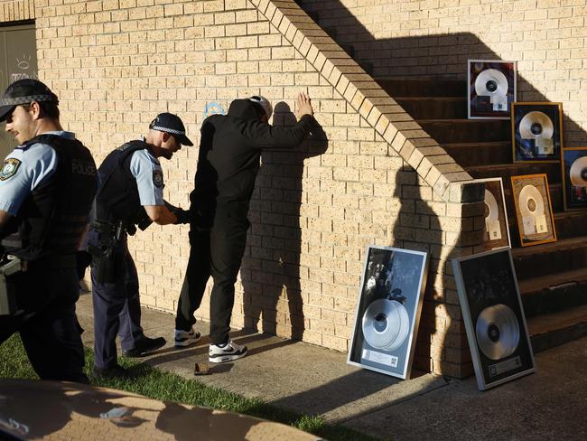 Police search a man during the Onefour photo shoot in Mt Druitt. Picture: Richard Dobson