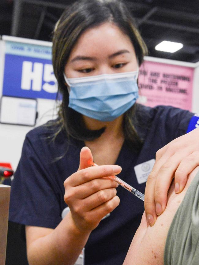 SA Health vaccinator Xuan gives a Covid booster vaccine at Wayville Vaccination Clinic. Picture: NCA NewsWire/Brenton Edwards