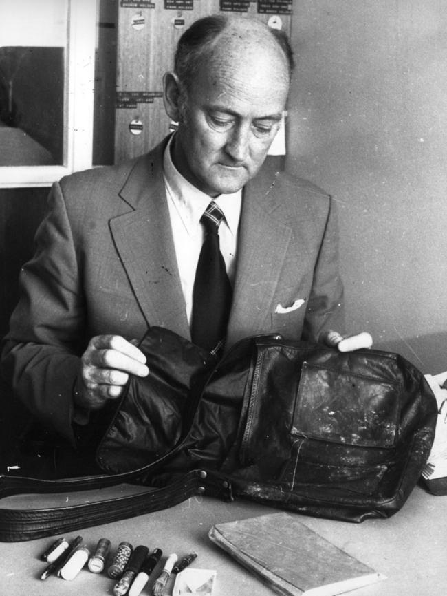 An investigating officer displays Juanita Nielsen’s handbag and its contents.