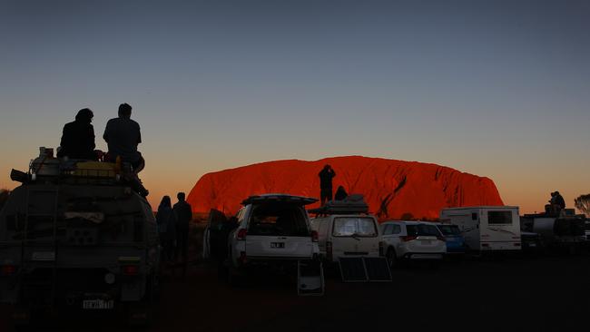 Visitors take in the sunset view of Uluru ... Territory tourism figures say the Gunner Government should offer incentive packages to attract interstate holiday makers back to the NT. Picture: Lisa Maree Williams