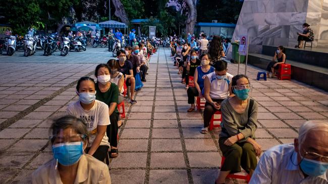 People wait in a queue to receive their first dose of the AstraZeneca vaccine. Picture: Linh Pham