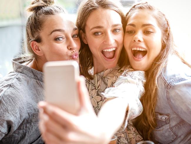 Three female friends taking selfie in Cafe smiling and one of friends making duck face. Picture: iStock