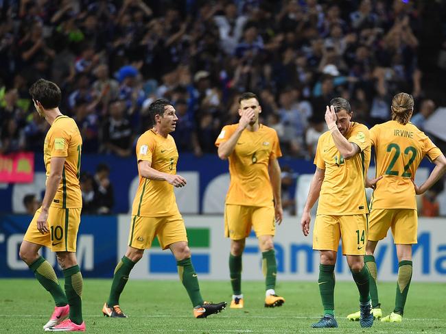 Australian players react to Japan's goal.