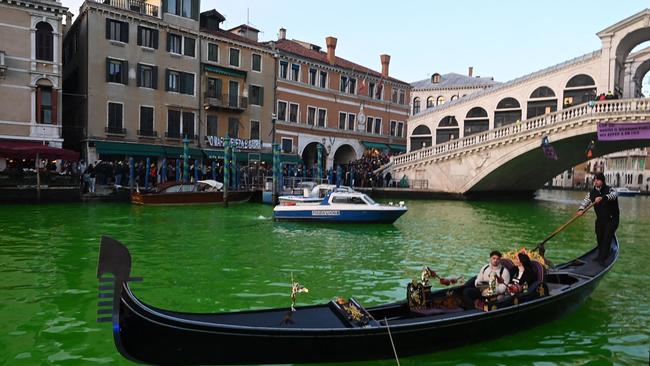 A gondola cruises on the Grand Canal in Venice after Extinction Rebellion activists poured fluorescein near the Rialto Bridge during a protest against the COP28 'fail' on climate. Picture: AFP