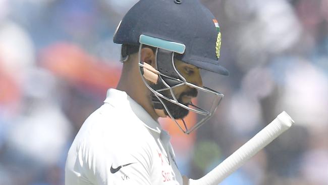 India's captain Virat Kohli walks back after getting out on the third day of the first cricket Test match.