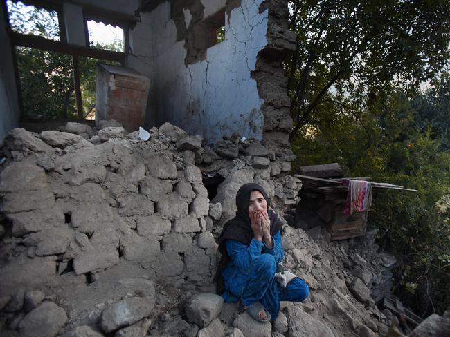 A woman who lost her two grandsons in the earthquake sits on the rubble of her destroyed home in Jinjara village in Chitral, Northern Pakistan.