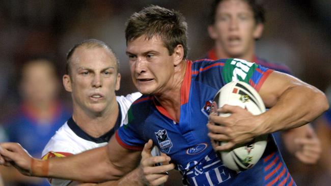 Riley Brown tries to evade the tackle of Broncos legend Darren Lockyer.