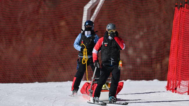 Germany's Dominik Schwaiger (C) is taken off the course with a stretcher