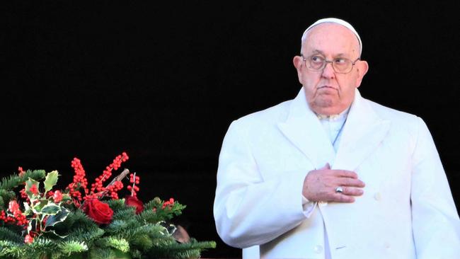 TOPSHOT - Pope Francis stands at the main balcony of St. Peter's basilica to deliver the Urbi et Orbi message and blessing to the city and the world as part of Christmas celebrations, at St Peter's square in the Vatican on December 25, 2024. (Photo by Alberto PIZZOLI / AFP)