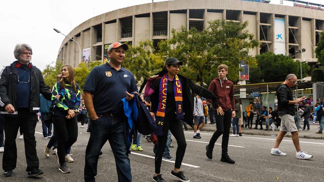 Football fans walk outside the Camp Nou