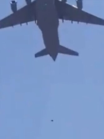 A person appears to fall from a US air force plane as it takes off from Kabul airport.