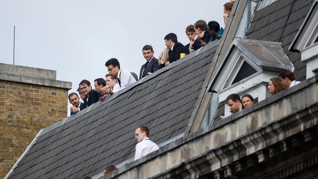 Members of the public look on from a rooftop as the coffin of Queen Elizabeth II passes during a procession from Buckingham Palace to Westminster Hall. Picture: John Sibley/AFP