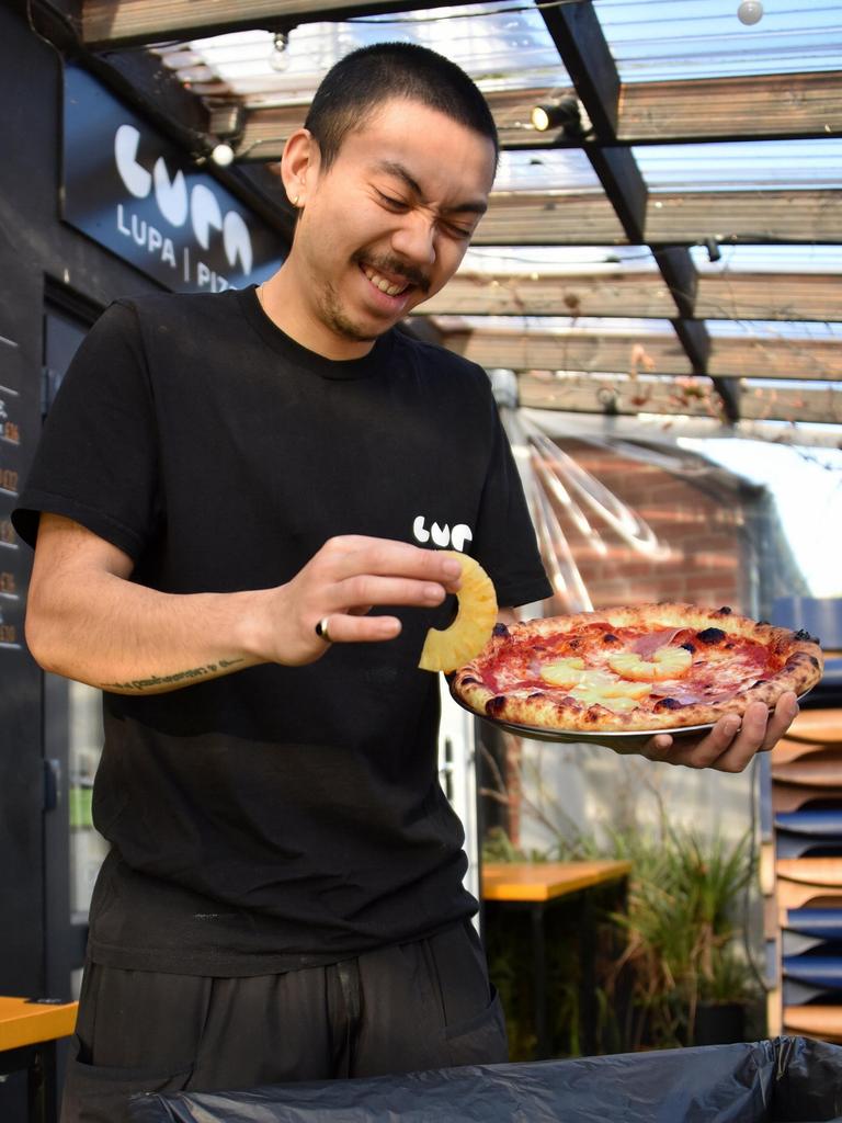 Chef Quin holds a pineapple pizza above the bin. Picture: SWNS