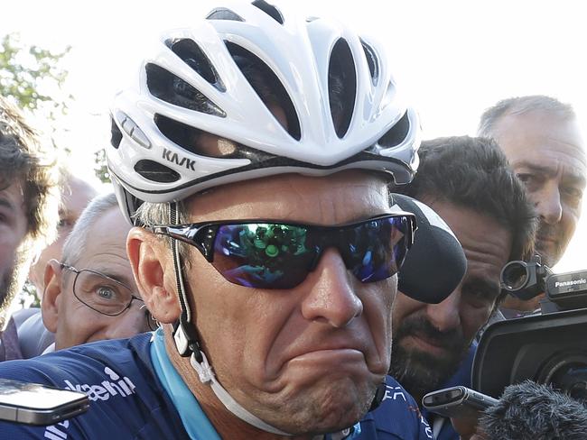 Lance Armstrong is surrounded by journalists as he joins former England footballer Geoff Thomas and his team of ten amateur riders for two stages of the "Le Tour-One Day Ahead" Thursday, July 16, 2015, in Le Muret, southeastern France. While the Tour de France is going on, Armstrong, who was stripped of seven consecutive Tour titles, takes part in a charity ride called "Le tour-One Day Ahead" Thursday and Friday with the goal of raising money to fight leukemia, taking the same route that Tour riders will cover a day later. (AP Photo/Lionel Cironneau)