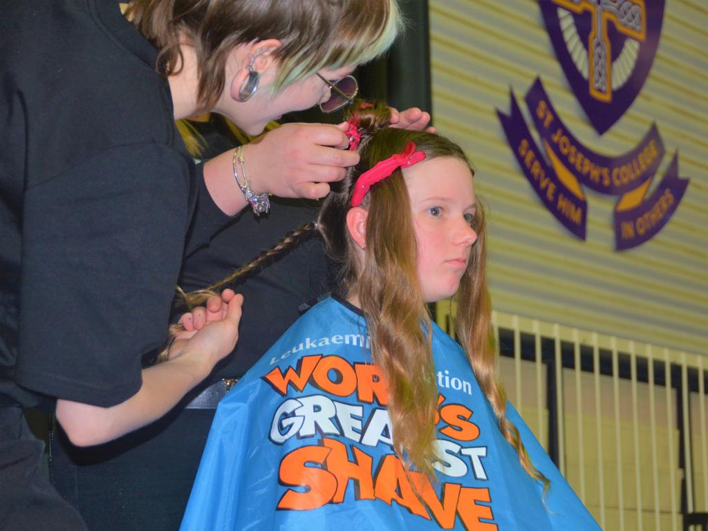 At the St Joseph's College 2023 World's Greatest Shave event is student Meghan Ellis having her cut by hairdresser Caitlin Symes from the Hair Room on Russell. Picture: Rhylea Millar