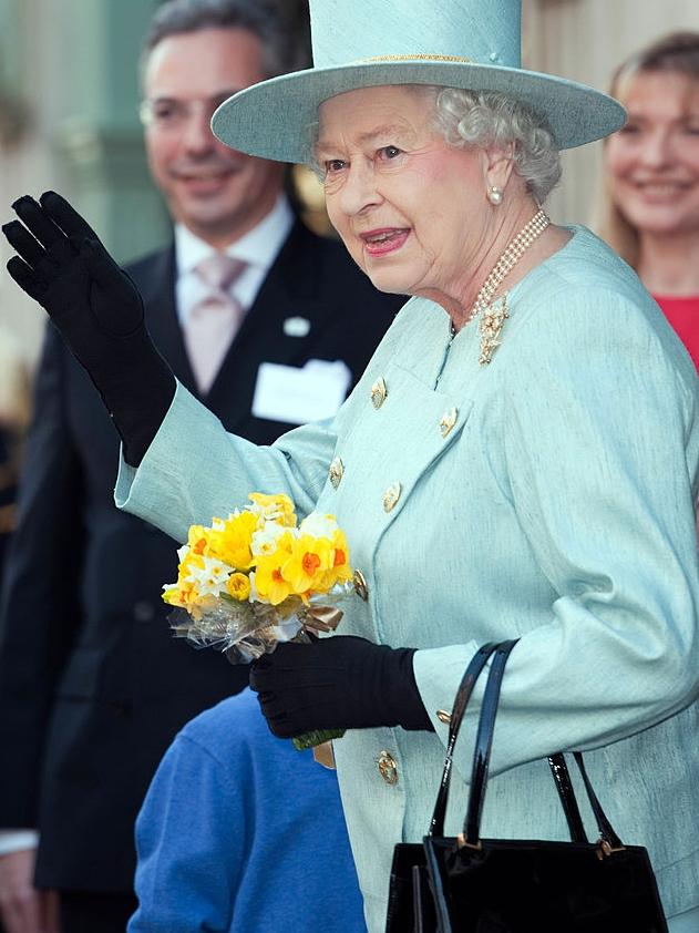 Queen Elizabeth II wearing Fortnum &amp; Mason colours in 2012 with a Launer handbag on her arm. Picture: Getty Images