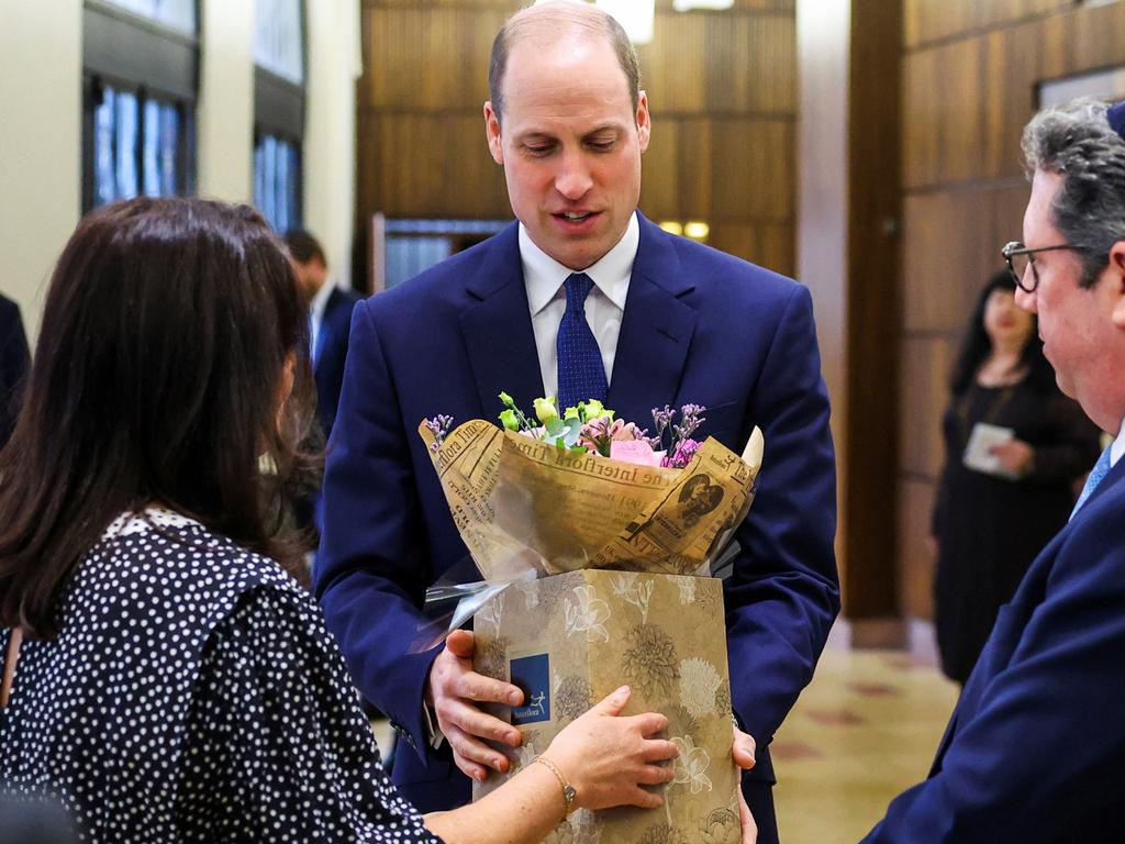 Prince William receives flowers for his wife during a visit to a London synagogue. Picture: Getty Images