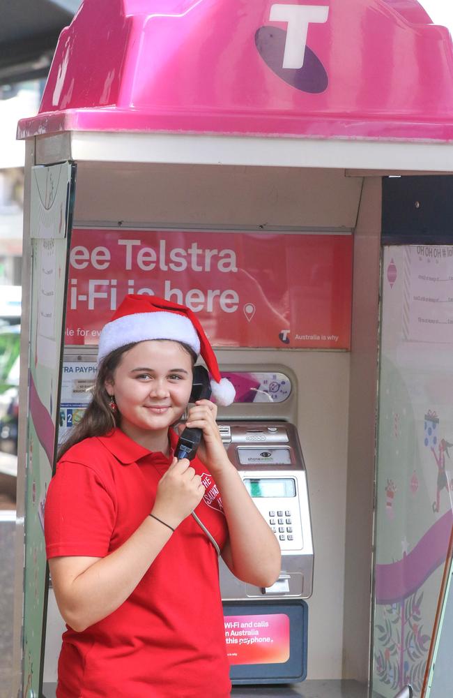 Lilly Courtney uses a payphone in Darwin to call Santa’s workshop and speak with the festive team in the North Pole. Picture: Glenn Campbell