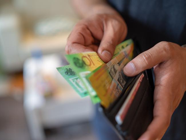 a male taking money out of a wallet, Australian cash generic spending