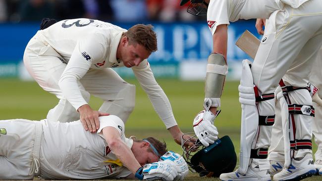 Smith lies stunned on the pitch as his concerned Australian teammate Pat Cummins (right) and England’s Jos Buttler come to his aid. Picture: AFP