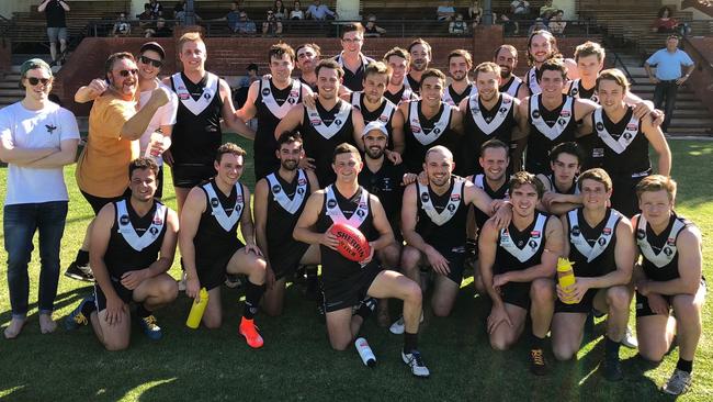 Adelaide University players celebrate victory in Hugh Woods’ (pictured with the footy) comeback game. Picture: Adelaide University Football Club.