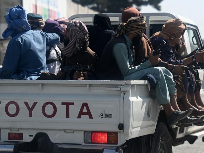 Taliban fighters patrol Kabul International Airport as gunfire was heard in the city falsely celebrating the fall of Panjshir Valley. Picture: AFP