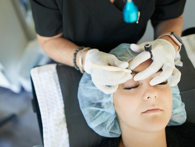 Shot of a young woman getting her eyebrows microbladed . eyebrows brows technician istock