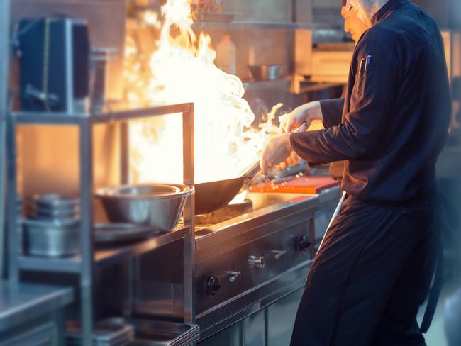 Chefs preparing asian food in restaurant kitchen. Preparing Yakiudon. This is real chefs not models.