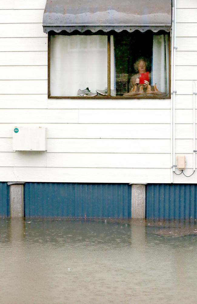 A resident looking out of her window at Torwood St, Milton. Picture: Steve Pohlner