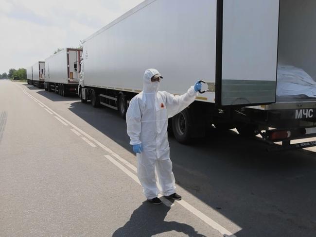 Russian orderlies open a refrigerator of the first convoy carrying bodies of Ukrainian soldiers for repatriation at an exchange area near Novaya Guta, Belarus. Picture: AP