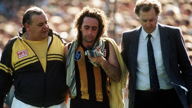 A concussed John Platten is taken back to the Hawthorn rooms.