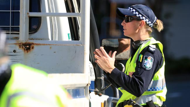 A Queensland Police officer speaking to a driver at a Coolangatta checkpoint. Picture: Adam Head