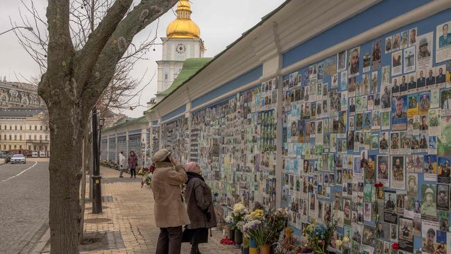 A woman looks at a photo of her son Tymofii Boyko, a Ukrainian soldier who was killed fighting Russian troops, on the Wall of Remembrance of the Fallen for Ukraine in Kyiv. Picture: Roman Pilipey / AFP